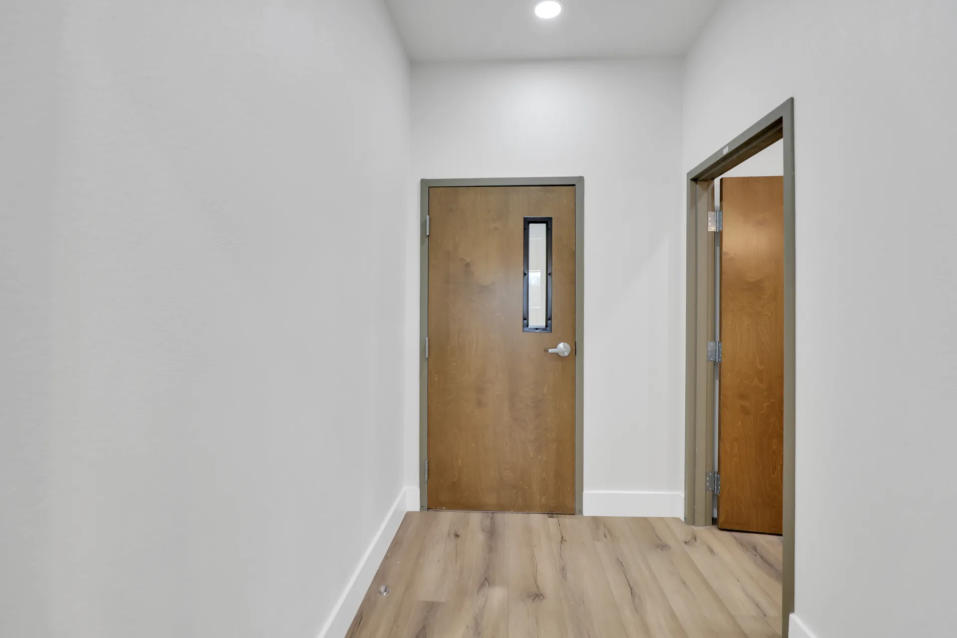 Interior hallway with wood doors connecting office and amenity areas in a Triple C Business Park unit